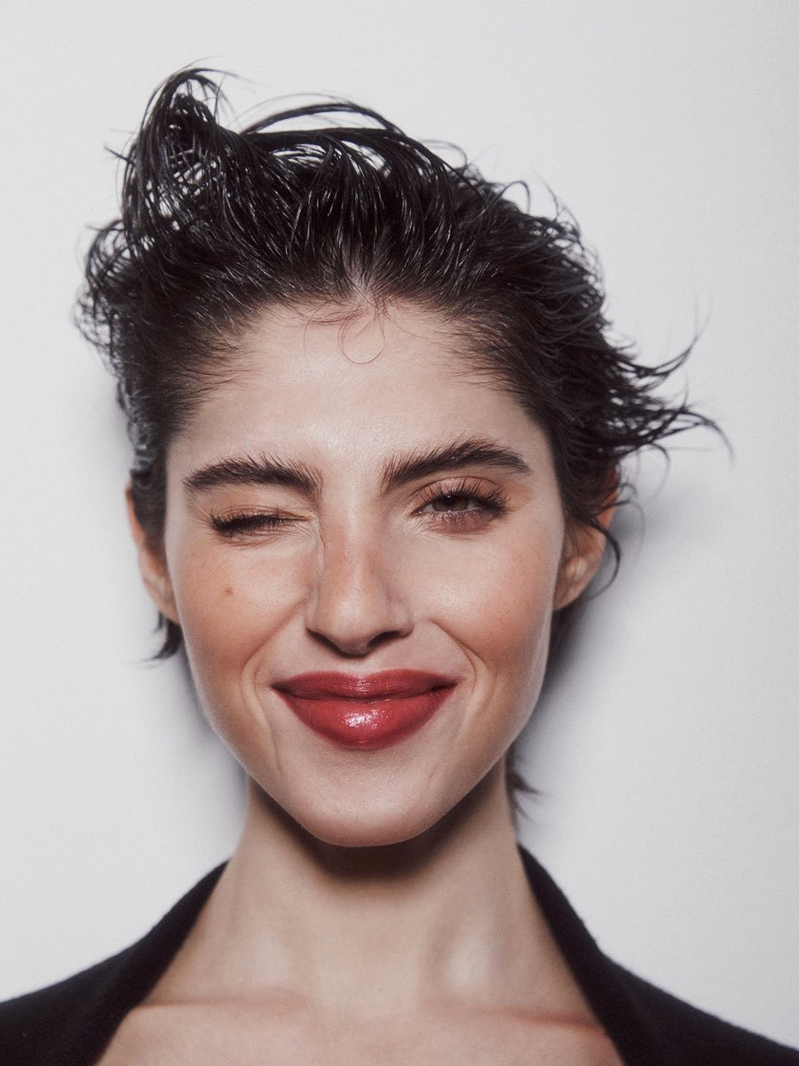 Ritratto beauty: pelle luminosa, ciglia definite e labbra rosso mattone lucide