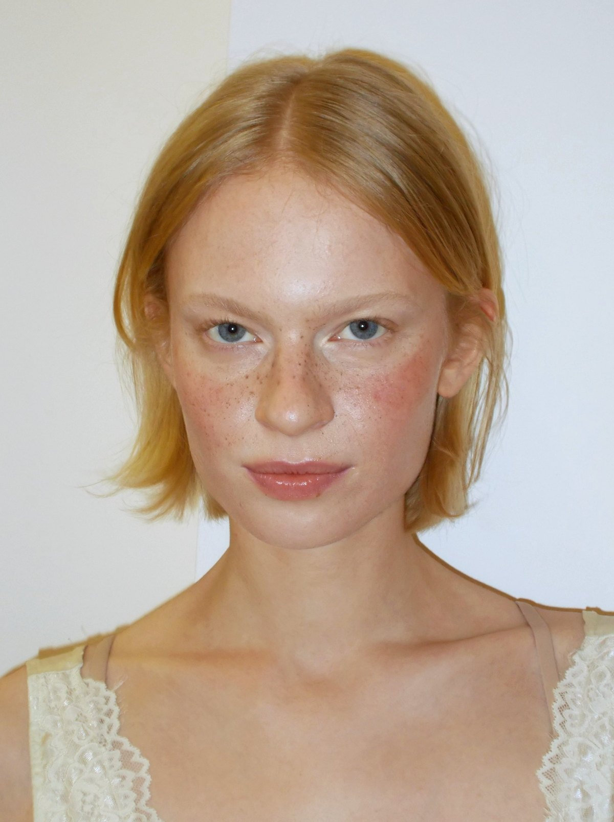 Ritratto beauty: pelle fresca con lentiggini, blush rosato e labbra nude glossy